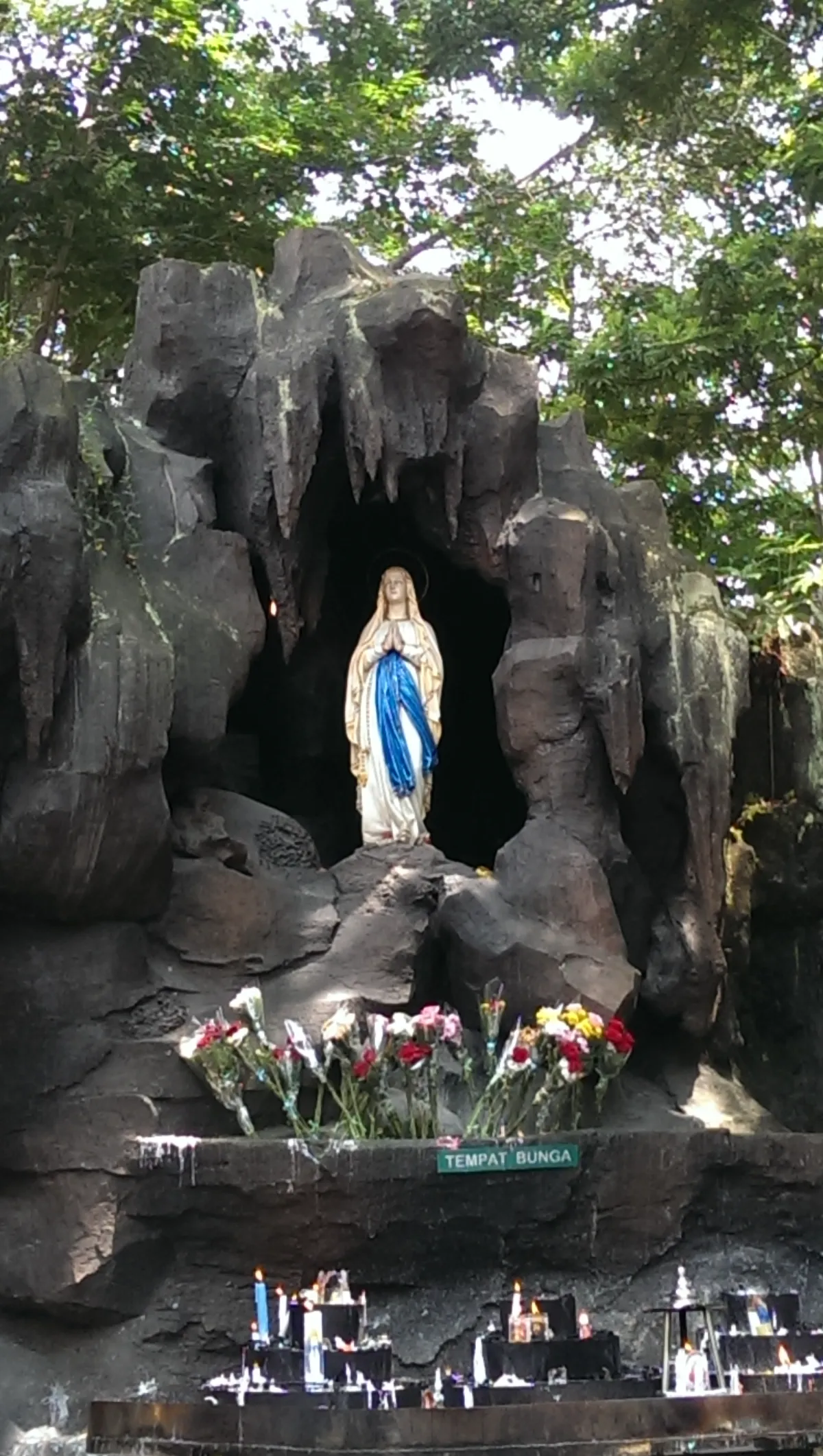 Gua Maria Kerep Ambarawa — patung Bunda Maria di ceruk batu dengan lilin peziarah
